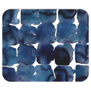 Puede incluir: Una alfombrilla de ratón rectangular con un diseño de acuarela de formas azules superpuestas sobre un fondo blanco. Las formas varían en tonos de azul claro a oscuro. La firma del artista, "lisa baudry", está en la esquina superior derecha.