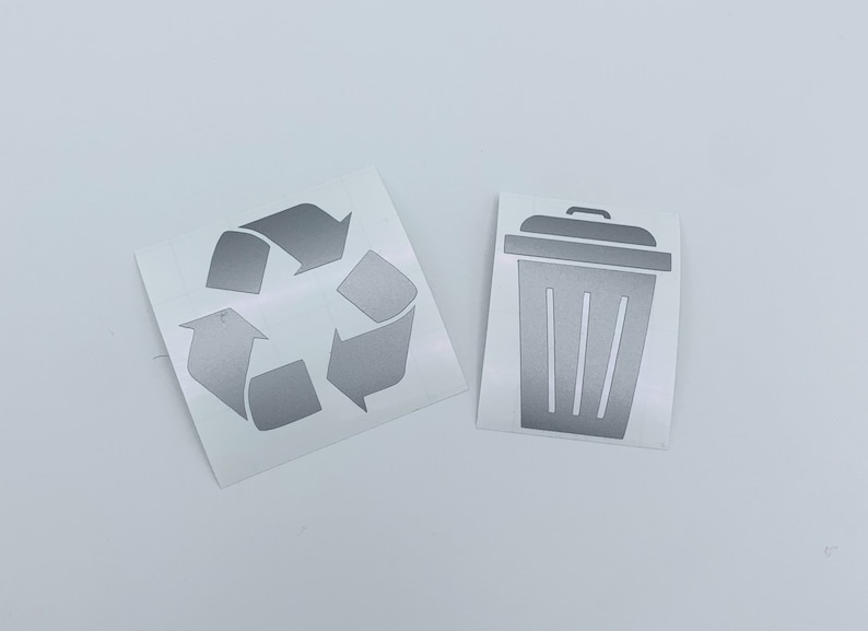 May include: Two silver vinyl stickers, one with a recycle symbol and the other with a trash can icon.