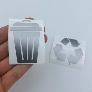 May include: Two silver vinyl stickers, one with a trash can icon and the other with a recycling symbol.
