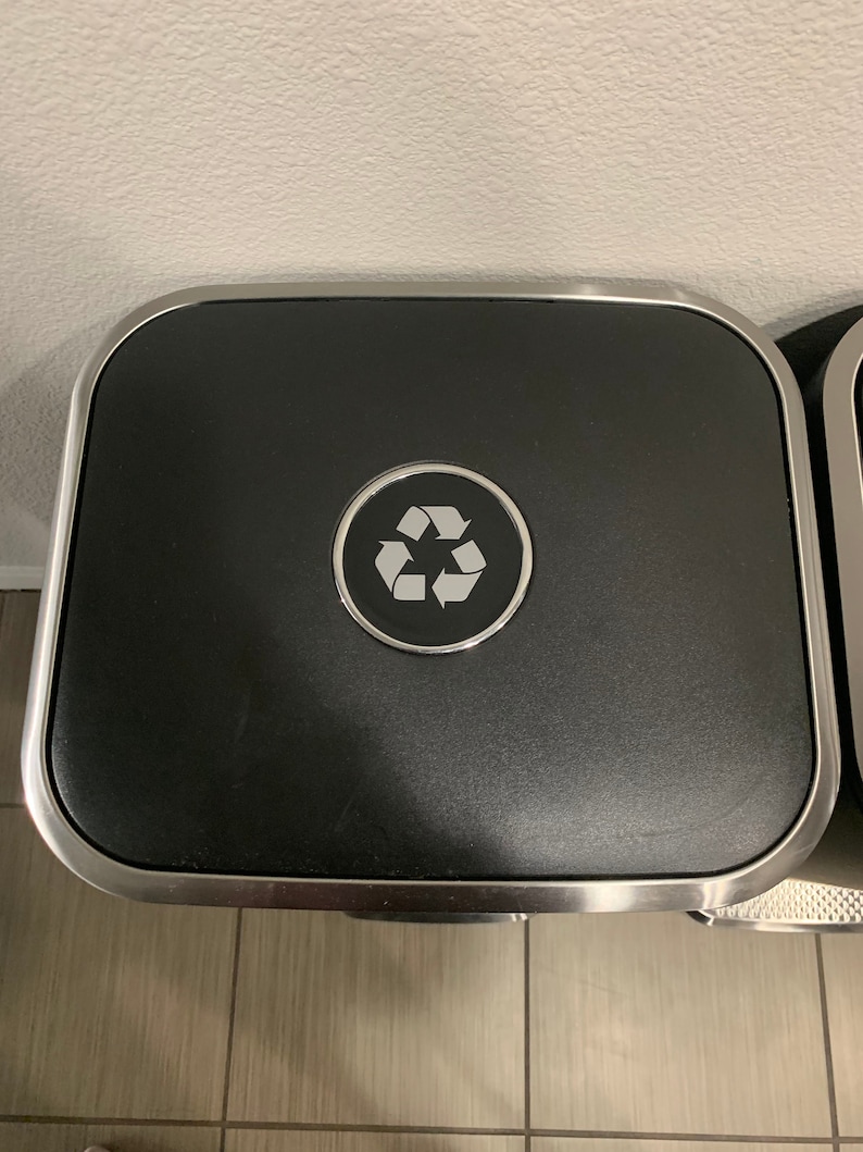 May include: A silver and black recycling bin with a recycle symbol on the lid.
