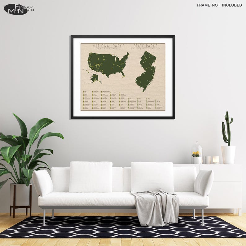 May include: A framed map of the United States with green markings showing the locations of national and state parks. The map is on a beige background with a list of park names below. The map is hanging on a white wall above a white couch.