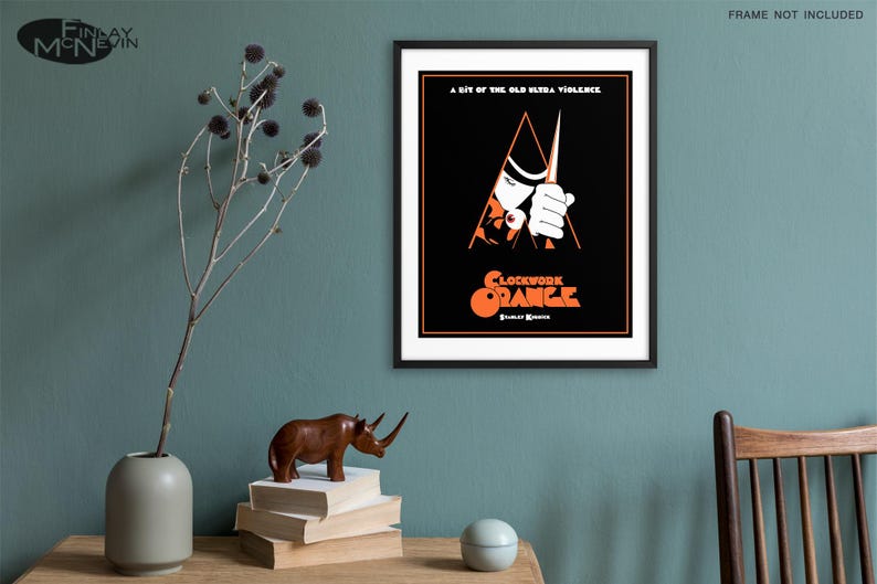 May include: A black and white poster with a red and orange graphic of a man holding a knife. The text on the poster reads "A bit of the old ultra-violence" and "Clockwork Orange".