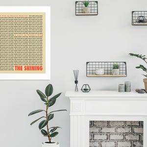 May include: A beige poster with the title "The Shining" in red text. The poster is a film and novel credit for the movie "The Shining" by Stephen King.