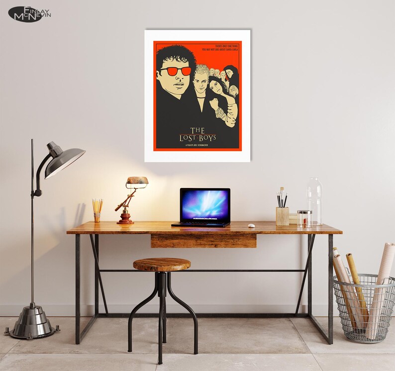 Puede incluir: Un p&oacute;ster minimalista con fondo rojo que presenta una ilustraci&oacute;n en blanco y negro de los personajes principales de la pel&iacute;cula "The Lost Boys". El t&iacute;tulo de la pel&iacute;cula est&aacute; escrito en letras doradas debajo de la ilustraci&oacute;n.