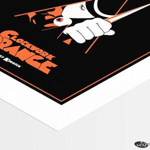 May include: A black and orange poster with the title "A Clockwork Orange" in orange text. The poster features a close-up of a person's eye and hand holding a knife.