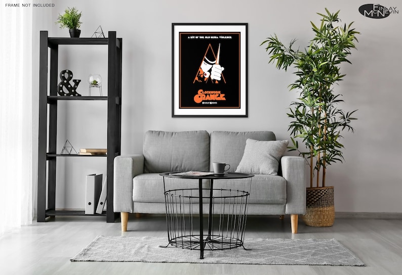May include: A black and white movie poster for the film "A Clockwork Orange" featuring a man in a white shirt and black hat holding a knife. The poster has a red and orange triangle in the background.