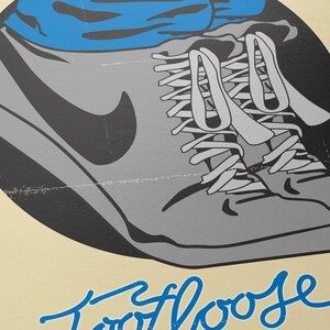 May include: A vintage-style poster with a blue and gray illustration of a person's feet wearing sneakers. The text "Footloose" is written in blue cursive script with the tagline "All he wanted to do was dance" below.