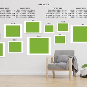 May include: A size guide for printed artwork, showing different paper sizes and corresponding image sizes. The guide includes measurements in inches and centimeters. The image also shows a living room setting with a chair and a side table, showcasing how the artwork would look in a home.