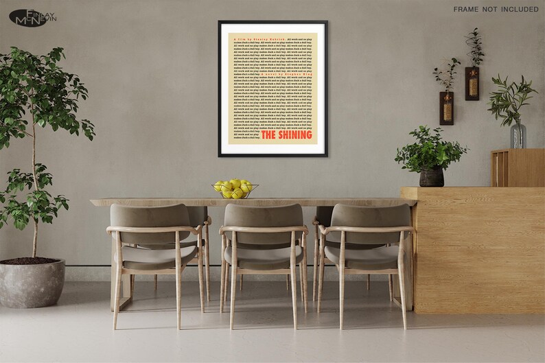 May include: A framed poster with a black frame and a beige background. The poster features a black and white text print of the entire script for the movie "The Shining" by Stephen King. The title "The Shining" is printed in red at the bottom of the poster.