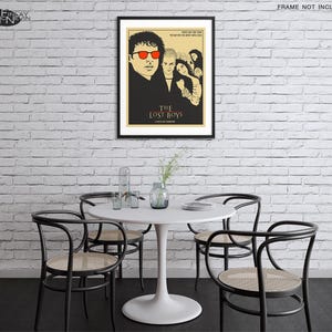 Puede incluir: Un p&oacute;ster en blanco y negro con un dise&ntilde;o minimalista que presenta el t&iacute;tulo "The Lost Boys" en fuente amarilla. El p&oacute;ster representa a un grupo de j&oacute;venes, uno de ellos con gafas de sol rojas, sobre un fondo oscuro.