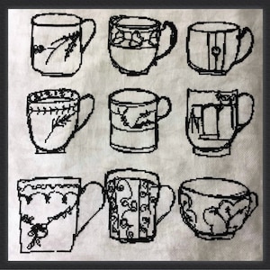 May include: Nine black and white cross-stitch mugs with various designs, including floral patterns, hearts, and geometric shapes. Each mug has a handle and sits on a white background. The mugs are all different.