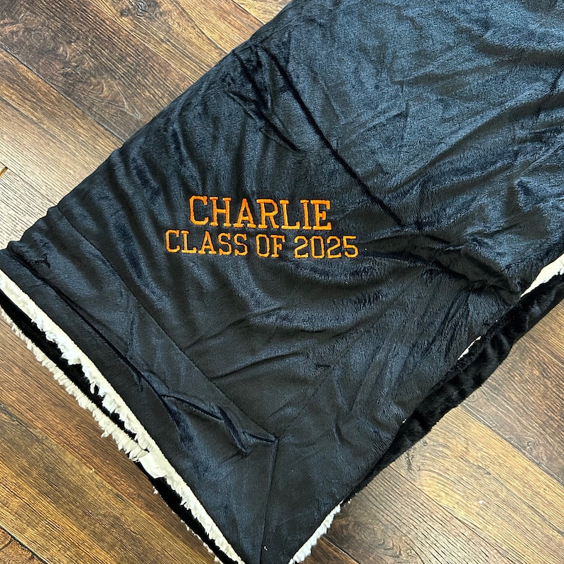May include: Black and white plush blanket with the text "CHARLIE CLASS OF 2025" embroidered in orange.