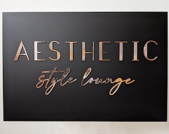 May include: A black sign with gold lettering that reads "AESTHETIC style lounge".