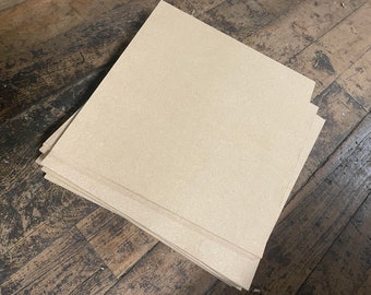 May include: A stack of beige cardboard sheets, likely for crafting or other DIY projects.
