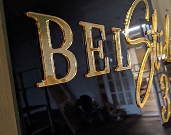 May include: A black sign with gold lettering that reads "BEL Studio".