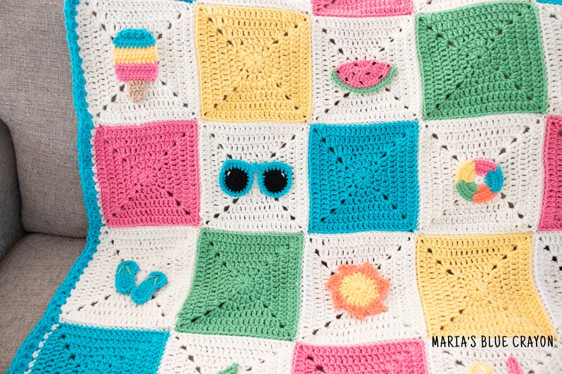 May include: A colourful crochet blanket with a summer theme. The blanket is made up of squares with different colours and designs, including a watermelon, sunglasses, an ice cream cone, flip flops, a beach ball, and a sun.