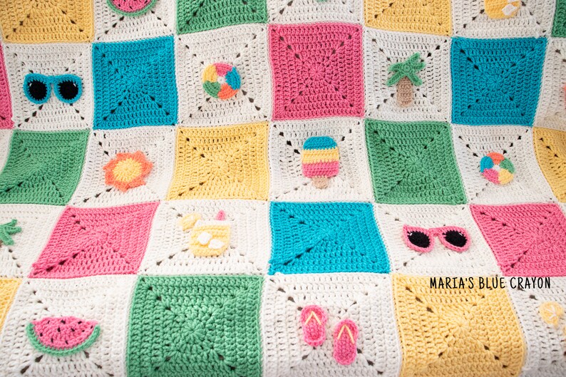 May include: A colourful crochet blanket with a summer theme. The squares are crocheted in different colours and feature various summer-themed appliques, including a watermelon, sunglasses, a beach ball, a palm tree, a popsicle, a sun, a pineapple, flip-flops, and a drink with an umbrella. The blanket is made with white, yellow, pink, blue, and green yarn.