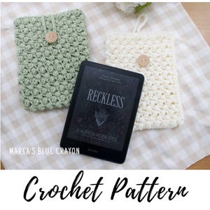 Pode incluir: Duas capas de Kindle de crochê, uma verde claro e outra creme, com fechos de botão de madeira. Um leitor de e-books Kindle exibe a capa do livro "Reckless" de Lauren Roberts. As palavras "Crochet Pattern" estão escritas abaixo.