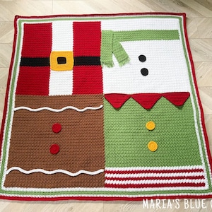 May include: A square crochet blanket featuring four distinct holiday-themed quadrants: a red Santa suit with a black belt and yellow buckle, a white snowman with a green scarf, a brown gingerbread person, and a green elf outfit with red trim.