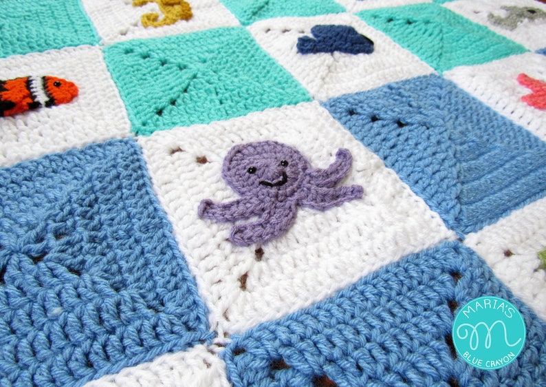 May include: A crocheted baby blanket with a blue, white, and turquoise color scheme. The blanket features a variety of sea creatures, including an octopus, a seahorse, and a fish. The blanket is made with a soft, textured yarn.