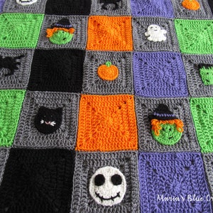 May include: A crocheted Halloween blanket with squares in green, orange, gray, black, and purple. Each square features a different Halloween character, including a witch, a ghost, a pumpkin, a cat, a spider, a Frankenstein, and a Jack Skellington.
