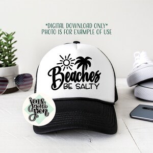 May include: A black and white trucker hat with a white front panel featuring a sun, palm tree, and the text "Beaches Be Salty".