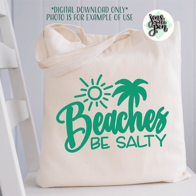 May include: A white tote bag with a green design of a sun, palm tree, and the text "Beaches Be Salty".