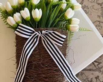 Fausses tulipes blanches dans un panier tressé