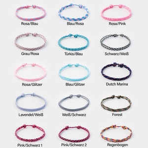 May include: A collection of 15 colorful friendship bracelets with various patterns and colors, including pink, blue, gray, black, white, turquoise, glitter, and rainbow. The bracelets are made of string and have a knot at the end.