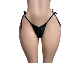 May include: A black bikini bottom featuring a minimalist design with thin side ties. The garment is constructed from a smooth, solid black fabric with a triangular front panel and thin straps that secure at the hips for an adjustable fit.