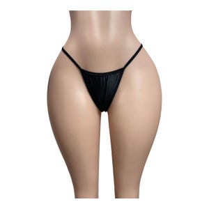 May include: A black thong featuring a minimalist design with thin side straps and a triangular front panel. The garment is constructed from a smooth, solid-colored fabric that provides a sleek appearance, showcasing a simple and functional cut.