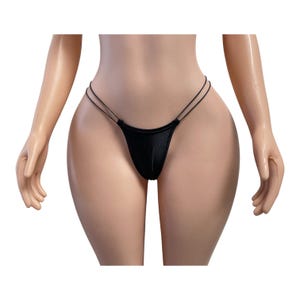 May include: A black thong featuring a minimalist design with a single front panel and thin, double-strap sides. The garment is constructed from a smooth, solid black fabric that provides a sleek appearance and sits low on the hips.