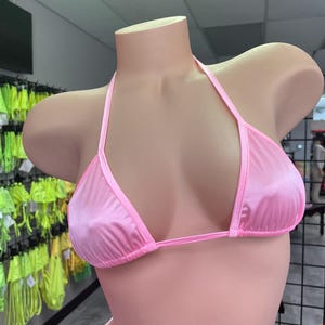 May include: A pink satin triangle bikini top with adjustable straps.