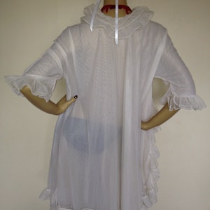 May include: White sheer nightgown with a ruffled collar and sleeves. The gown has a ruffled hem and is made of a lightweight fabric.