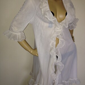 May include: White sheer robe with ruffled trim and a tie closure. The robe has a deep V-neckline and three-quarter sleeves.