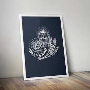 Puede incluir: Una ilustración en blanco y negro de un puño con una rosa y espigas de trigo, con el texto "Bread & Roses" debajo.