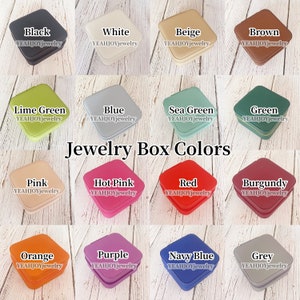 May include: A selection of 16 different colored jewelry boxes. The boxes are all square and have a diamond-shaped lid. The colors include black, white, beige, brown, lime green, blue, sea green, green, pink, hot pink, red, burgundy, orange, purple, navy blue, and grey.