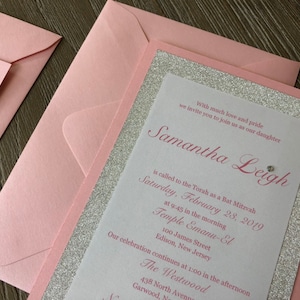 Pode incluir: Um convite rosa e prateado com detalhes de glitter. O convite &eacute; para uma celebra&ccedil;&atilde;o de Bat Mitzvah para Samantha Leigh. O evento acontecer&aacute; no s&aacute;bado, 28 de fevereiro de 2019, no Templo Emanu-El em Edison, New Jersey. A celebra&ccedil;&atilde;o continuar&aacute; no The Westwood em Garwood, New Jersey.