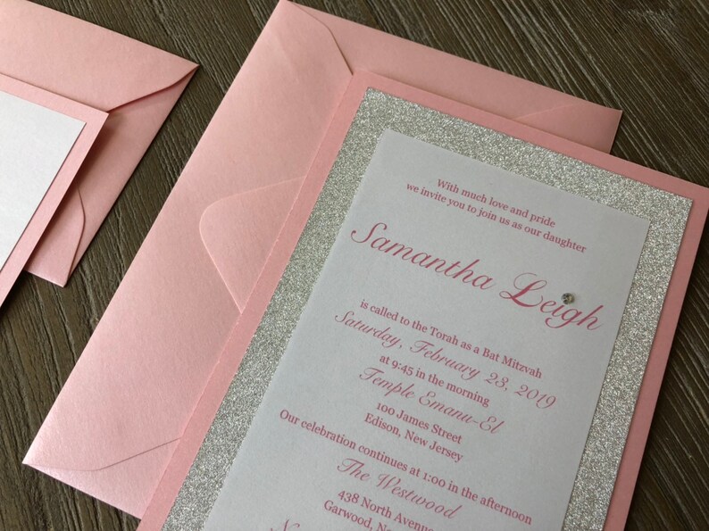 Pode incluir: Um convite rosa e prateado com detalhes de glitter. O convite &eacute; para uma celebra&ccedil;&atilde;o de Bat Mitzvah para Samantha Leigh. O evento acontecer&aacute; no s&aacute;bado, 28 de fevereiro de 2019, no Templo Emanu-El em Edison, New Jersey. A celebra&ccedil;&atilde;o continuar&aacute; no The Westwood em Garwood, New Jersey.