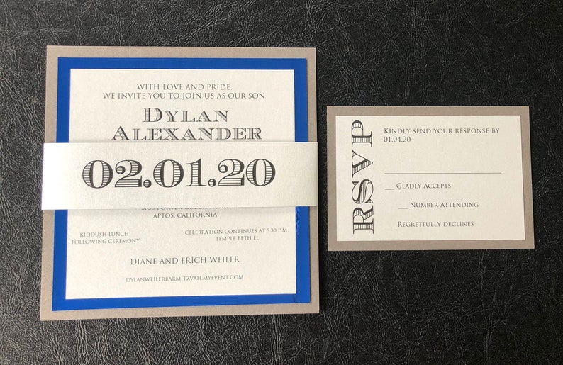 May include: A grey and blue invitation card with a white band. The card reads "With love and pride, we invite you to join us as our son Dylan Alexander 02.01.20 Aptos, California Kiddush lunch following ceremony Celebration continues at 5:30 pm Temple Beth El Diane and Erich Weiler Dylanweilerbarmitzvahmyevent.com". A separate grey card reads "RSVP Kindly send your response by 01.04.20 Gladly accepts Number attending Regretfully declines".