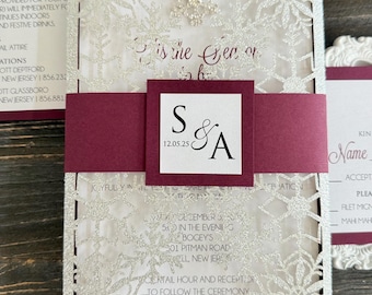 Invitación de boda de invierno con copos de nieve brillantes y capa burdeos