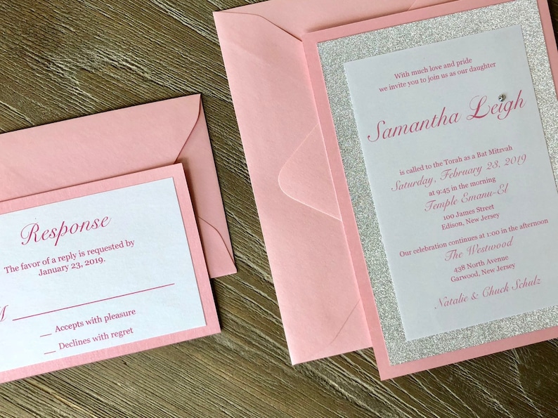 Pode incluir: Um convite rosa e prateado com detalhes de brilho para uma celebra&ccedil;&atilde;o de Bat Mitzvah. O convite inclui o nome Samantha Leigh, a data s&aacute;bado, 28 de fevereiro de 2019 e o local Temple Emanu-El. O convite tamb&eacute;m inclui o texto "Com muito amor e orgulho, convidamos voc&ecirc; a se juntar a n&oacute;s para celebrar nossa filha".