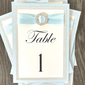 Numero di tavolo azzurro scintillante e glamour per matrimoni e occasioni speciali
