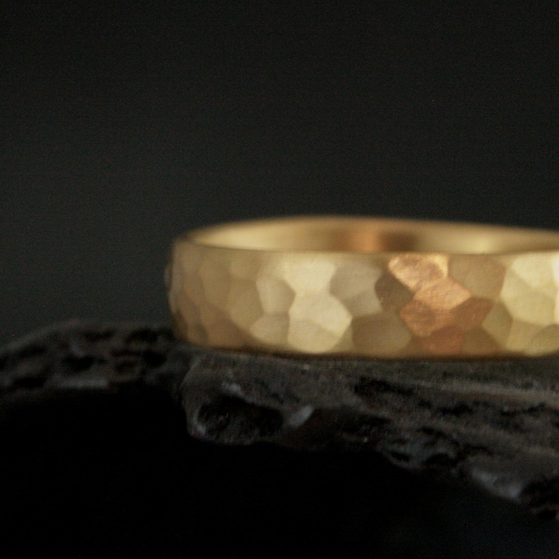 May include: A gold hammered wedding band with a textured surface.