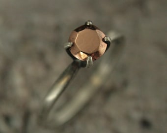 Anel solitário em ouro rosa com pedra facetada fundida em ouro, estilo Gold Rush, com quatro garras e diamante solitário, uma peça de arte conceitual.