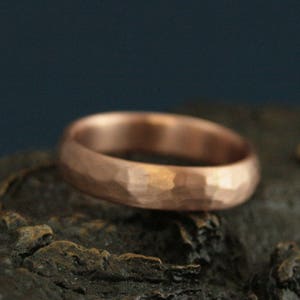 May include: A hammered copper wedding band with a rounded profile.