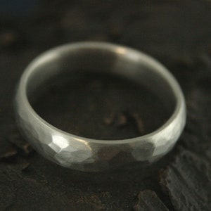 May include: A silver hammered wedding band with a smooth, polished finish.