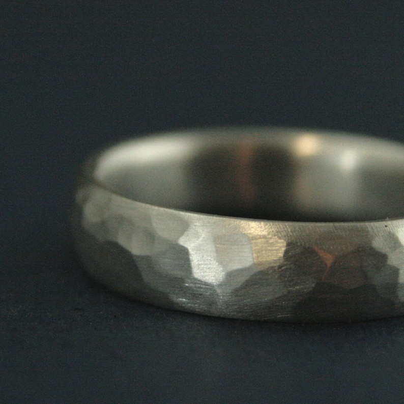 May include: A silver hammered wedding band with a textured finish.
