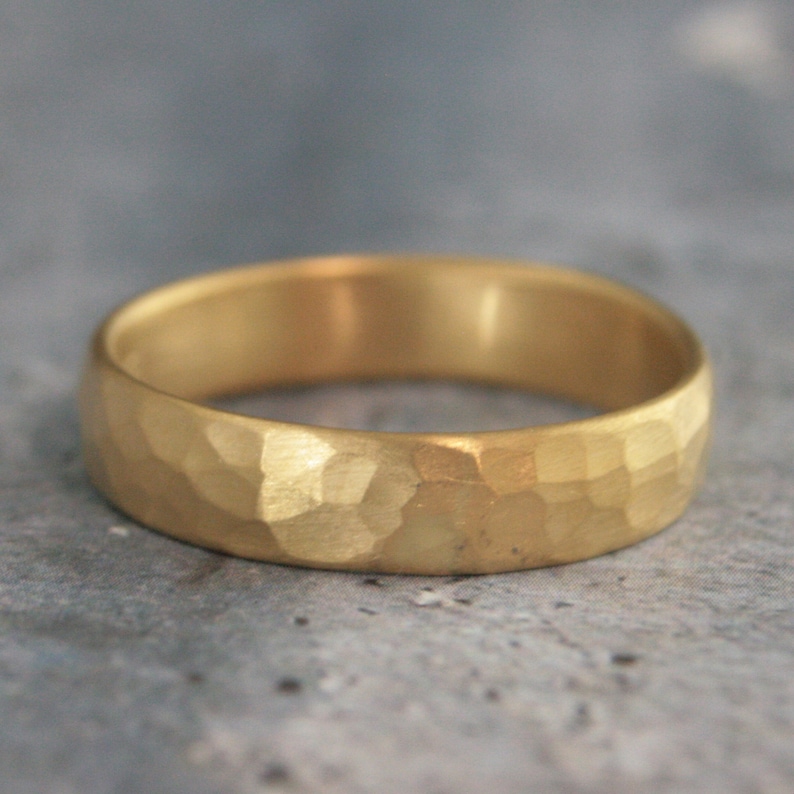 May include: A gold hammered wedding band. The band has a textured, hammered finish.