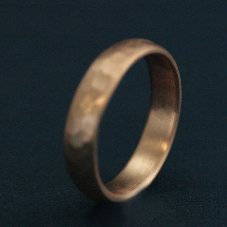 May include: A hammered gold wedding band with a brushed finish.